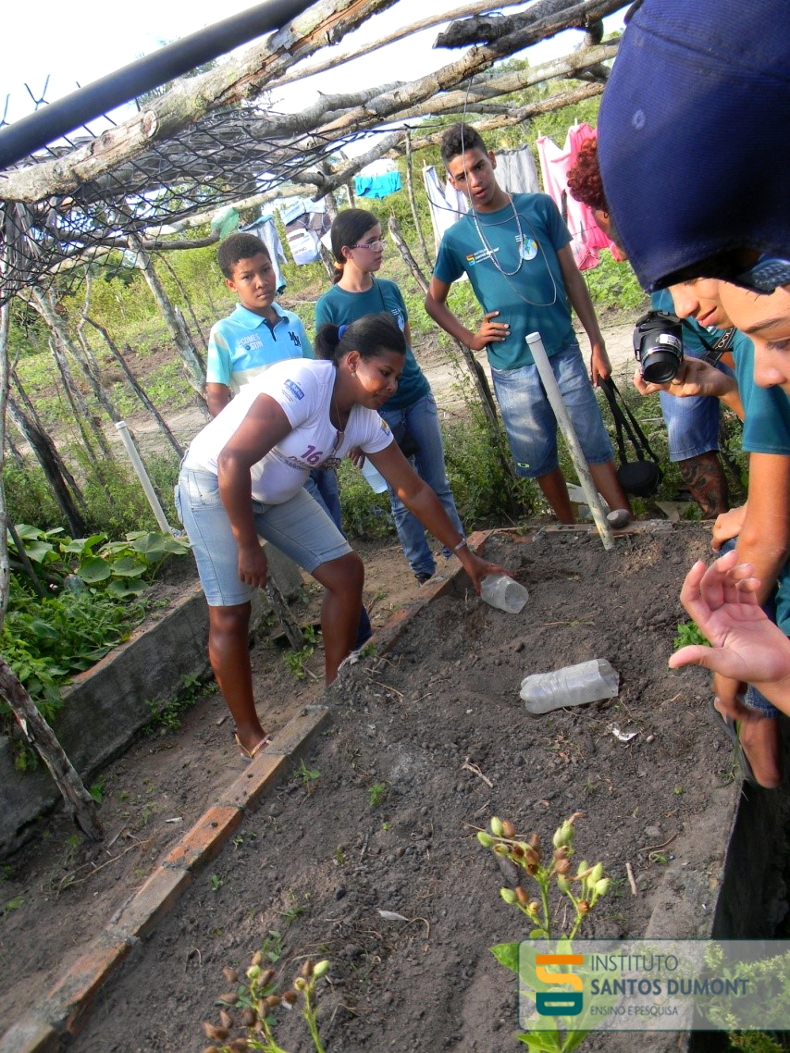 Jucicleide demonstra aos alunos o funcionamento do sistema de irrigação que a comunidade para a horta.